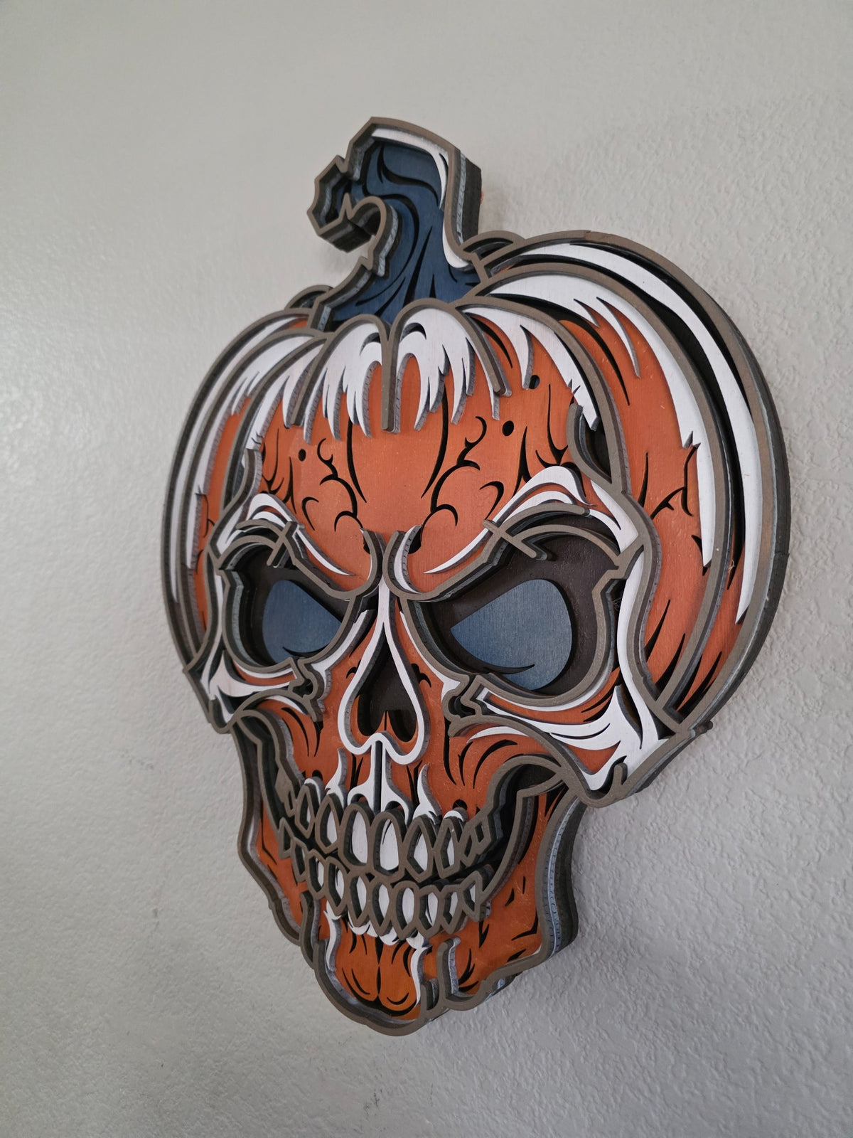 Side view of layered wooden pumpkin skull Halloween decor showing deep dimensional construction