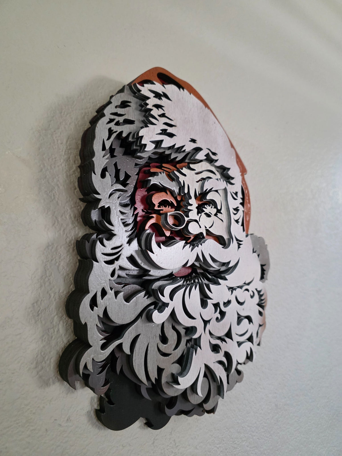 Angled side view of layered wooden Santa Claus wall art showing dimensional stacked wood layers